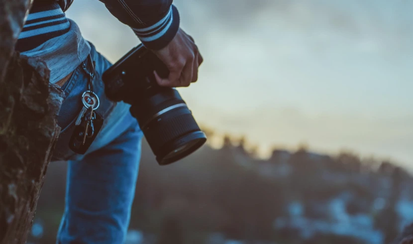 Person holding a camera loosely in their hand.